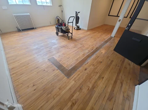 Before — light wood floor with a dark former-wall footprint and floor machine